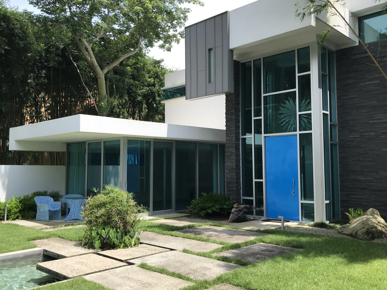 Modern home exterior glass entry courtyard – Glass & Walnut Modern Residence by Kancor Companies, Orlando, FL